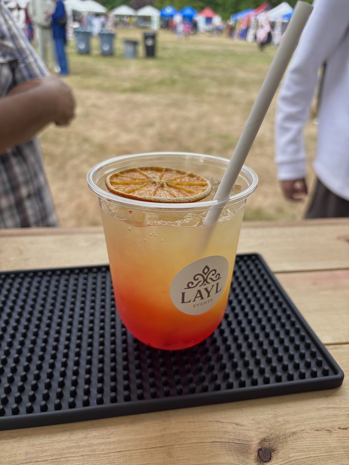 Golden Hour mocktail at the family day with vendor tents in the background